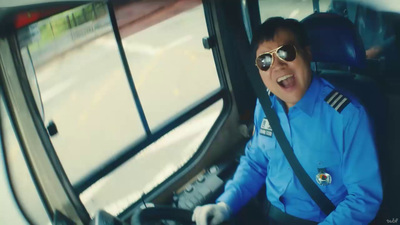 a man in a blue uniform driving a bus