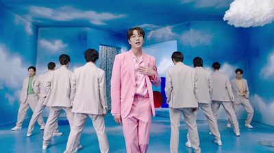 a man in a pink suit standing in front of a group of men