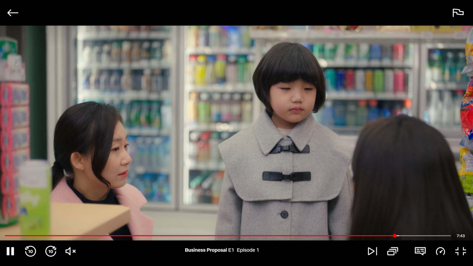 a little girl standing next to a woman in a store