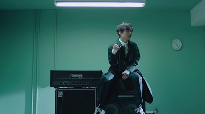 a man sitting on top of a chair next to a amp