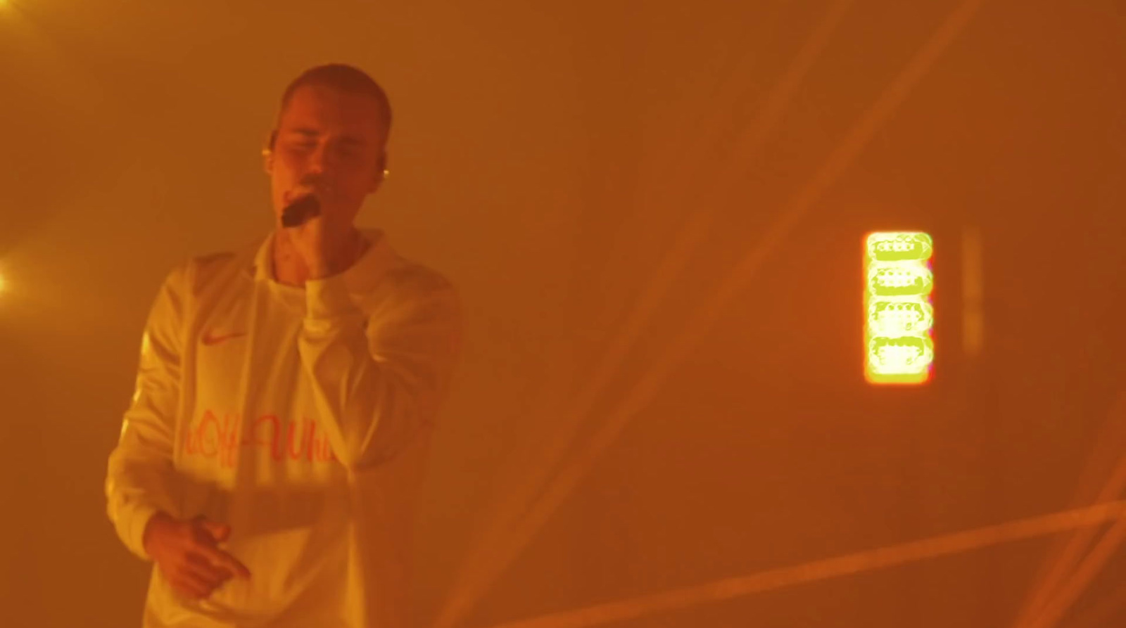 a man standing in front of a yellow light