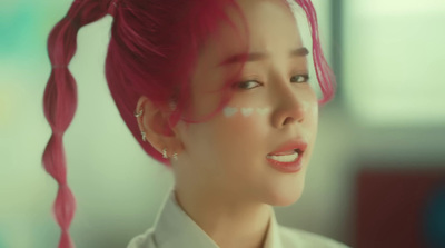 a woman with pink hair is wearing a white shirt