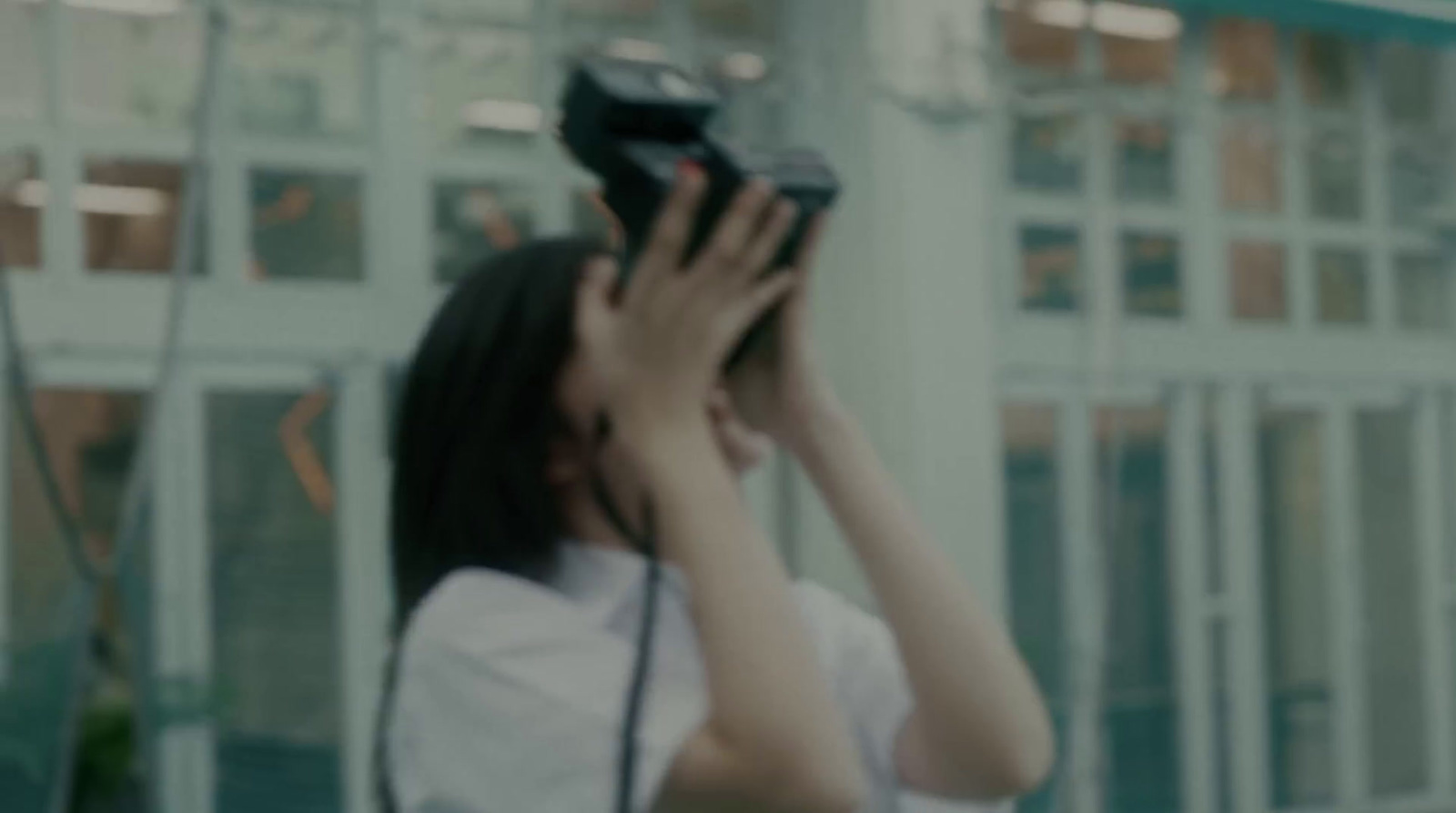 a woman holding a camera up to her face