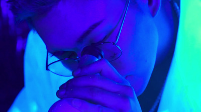 a man wearing glasses is looking at his cell phone