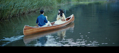 a man and a woman in a boat on a lake