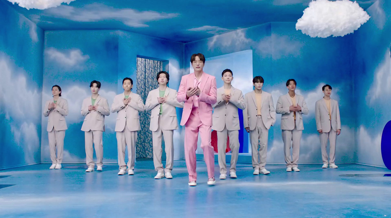 a man in a pink suit standing in front of a group of men