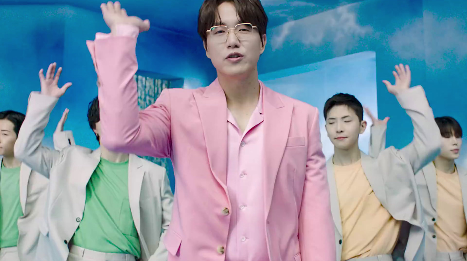 a man in a pink suit standing in front of a group of people