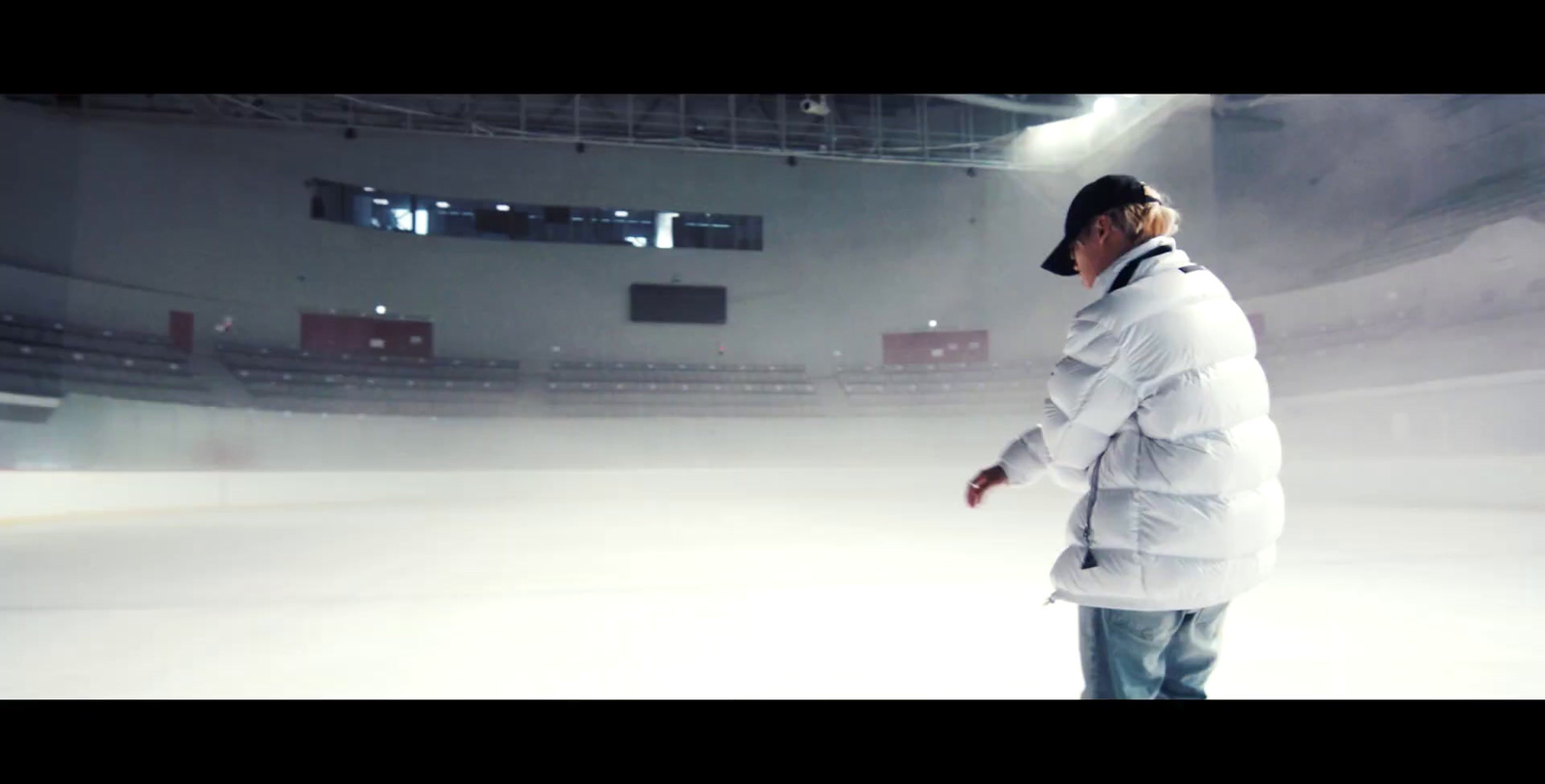 a man in a white coat standing in front of a stage