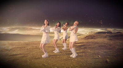 a group of women standing on top of a sandy beach