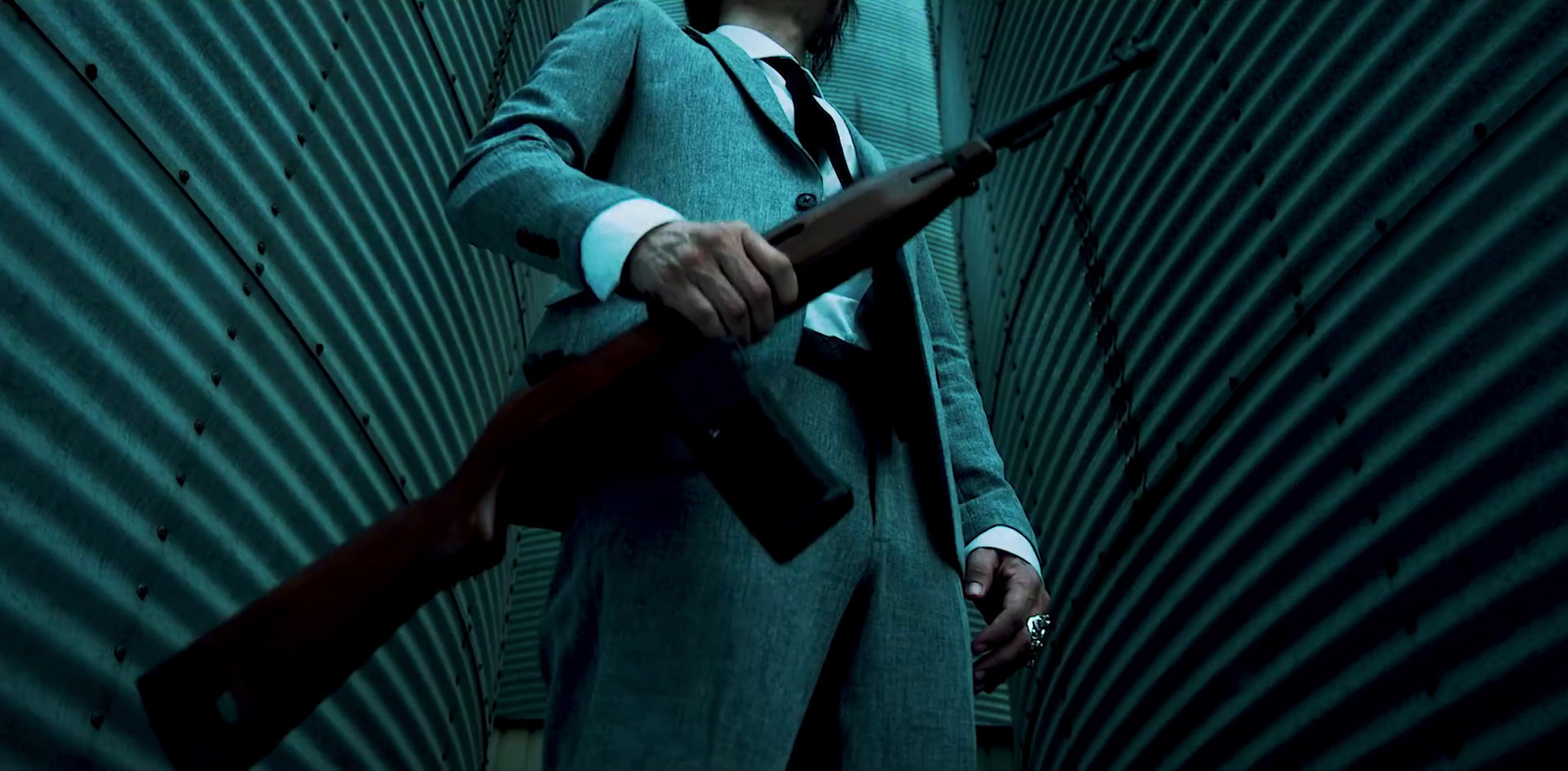 a man in a suit and tie holding a gun