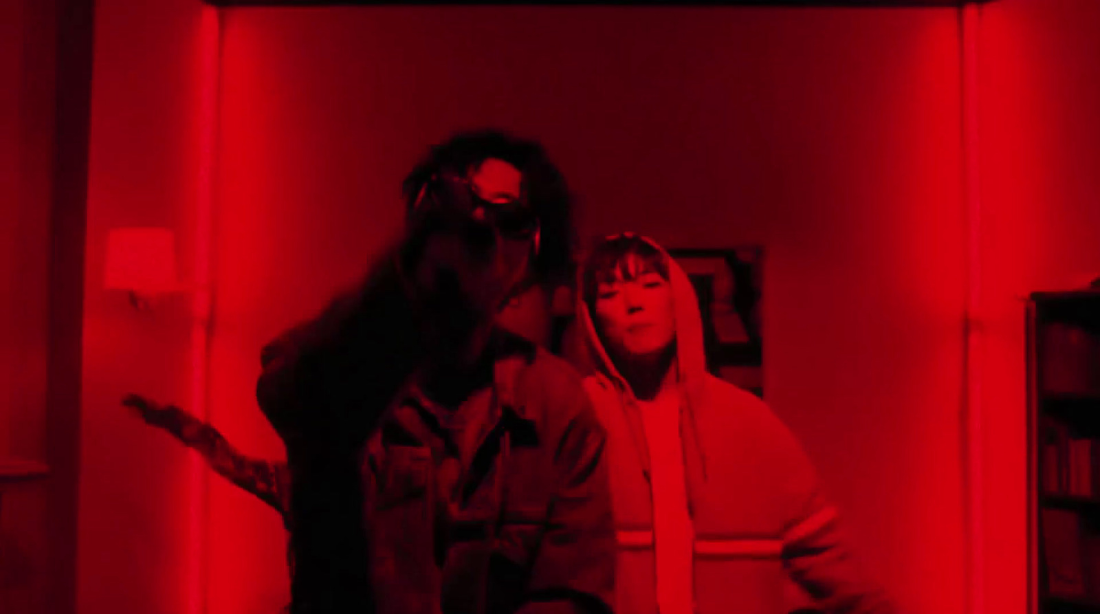 two people standing in a room with red lights