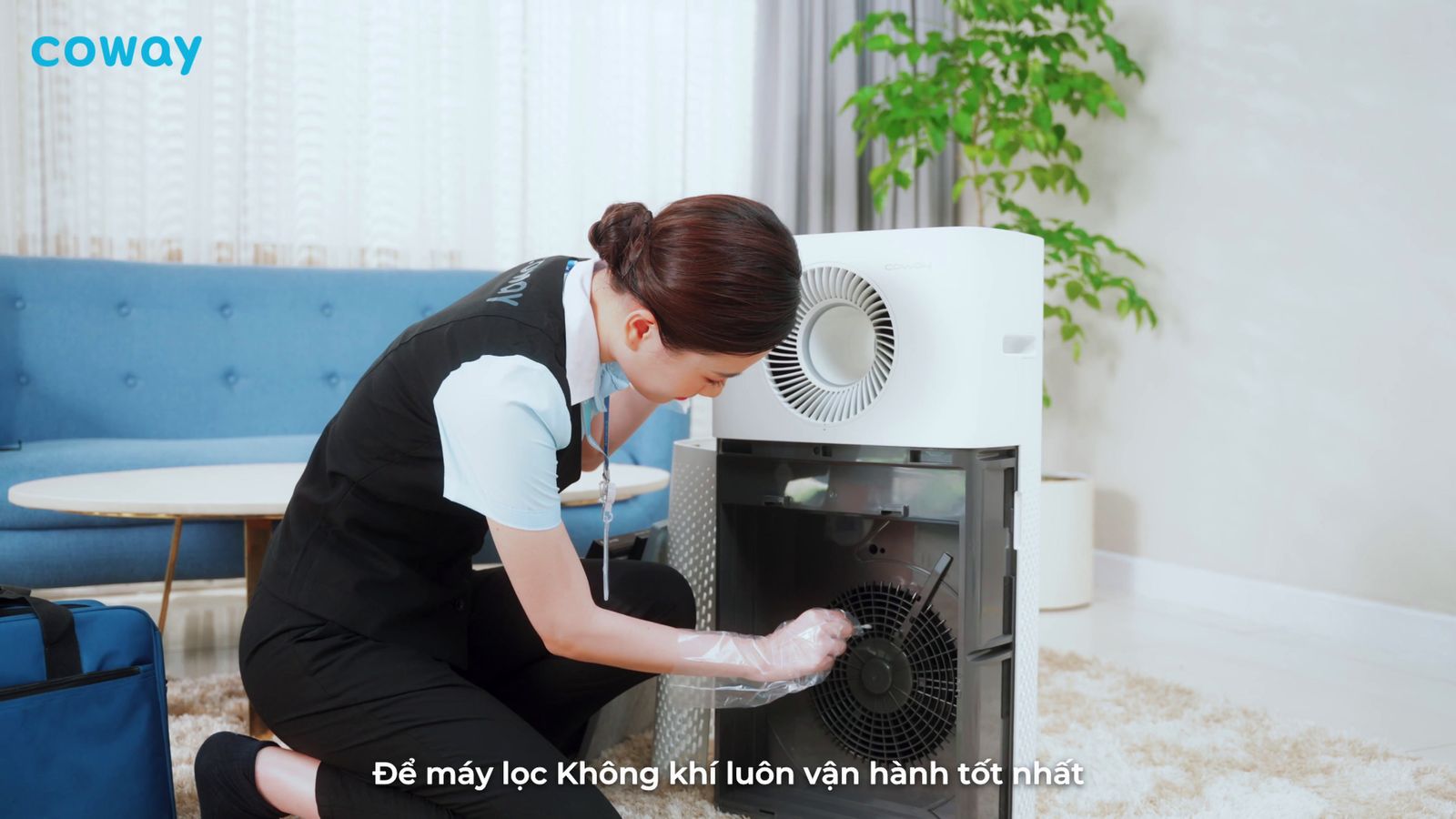 a woman kneeling down next to an air conditioner