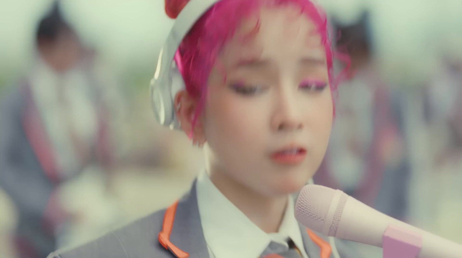 a girl with pink hair is holding a microphone