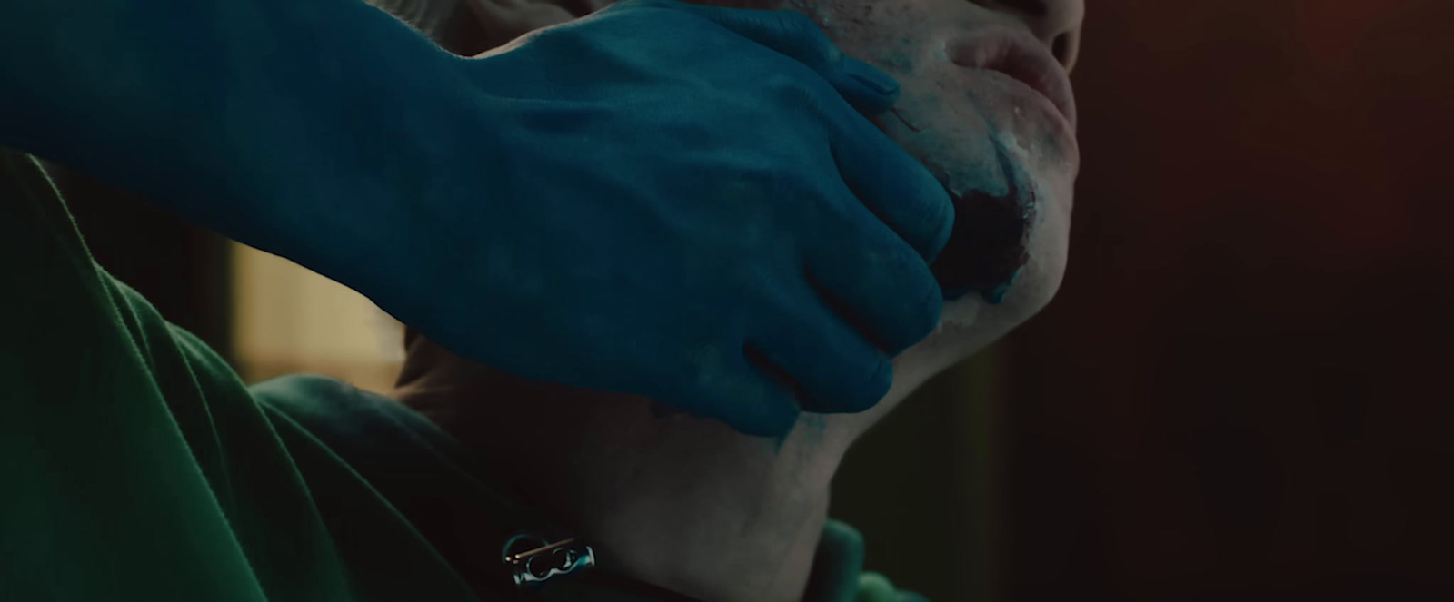 a person in a green shirt and blue gloves