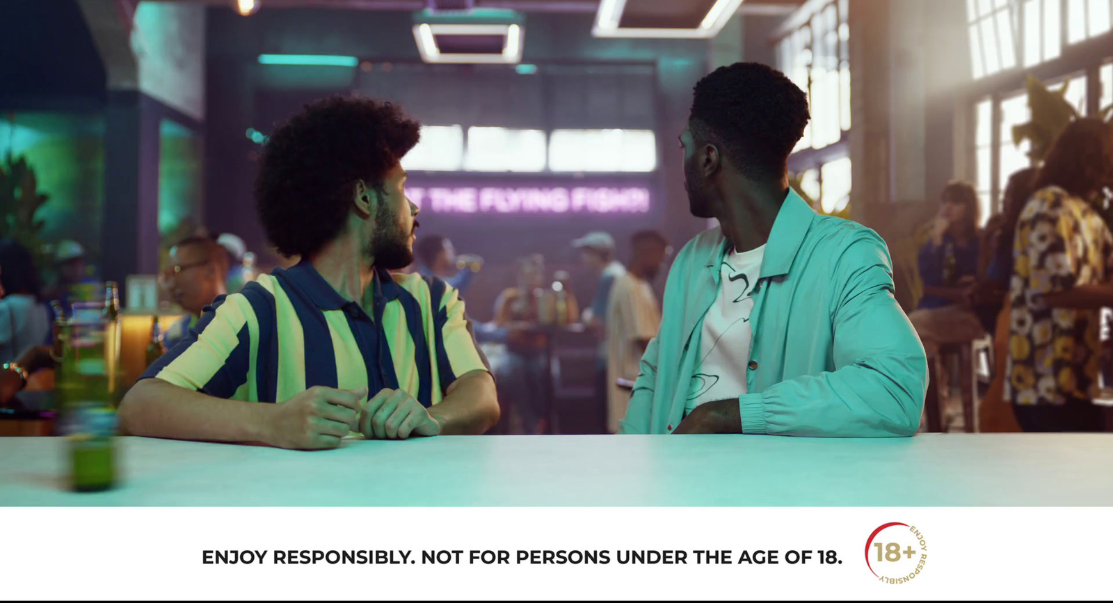 two men sitting at a table talking to each other