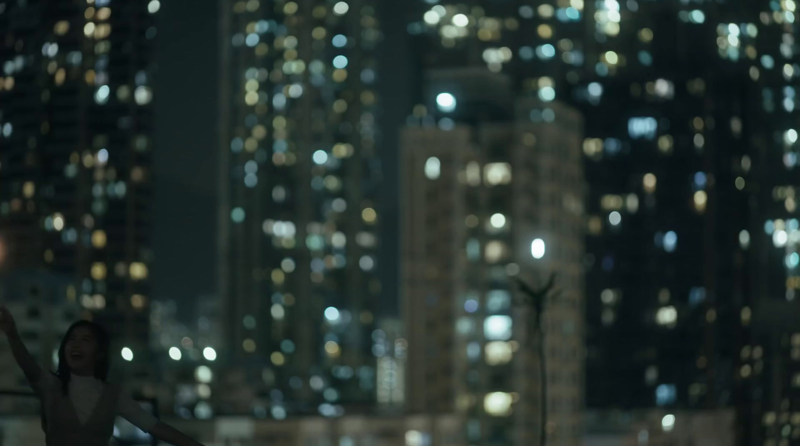 a woman standing in the middle of a city at night