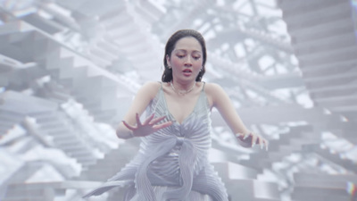 a woman in a white dress standing in front of a wall