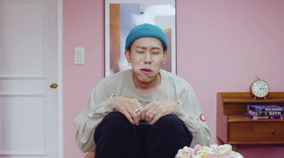 a man sitting on a table with a cake in front of him