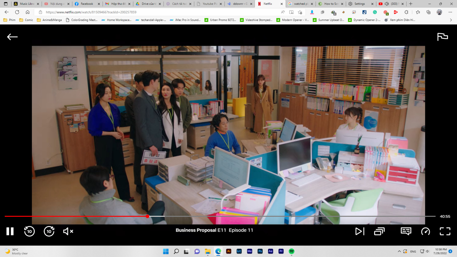 a group of people standing around a table with laptops