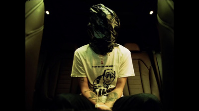 a man sitting in the back of a car wearing a paper bag on his head