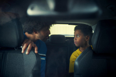 a man and a little girl sitting in the back of a car