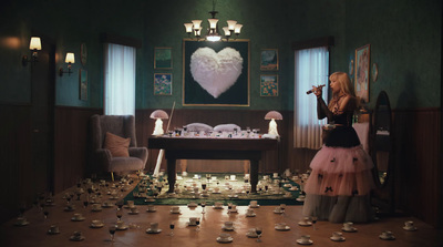 a woman standing in front of a table filled with tea cups