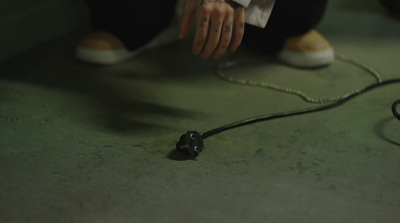 a person sitting on the ground holding a black object