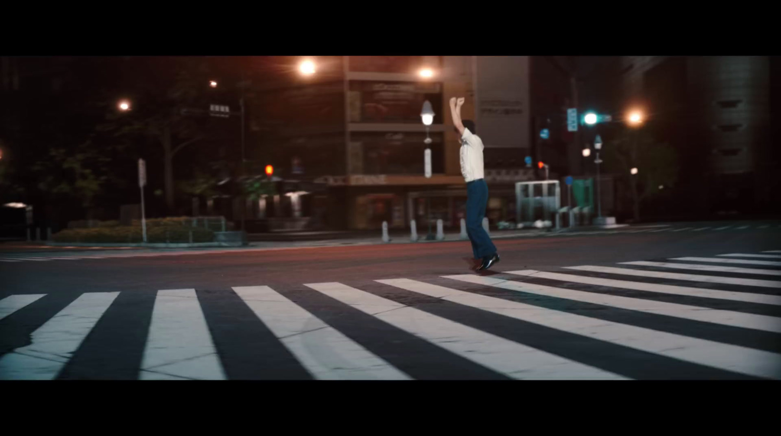 a person jumping in the air on a street at night