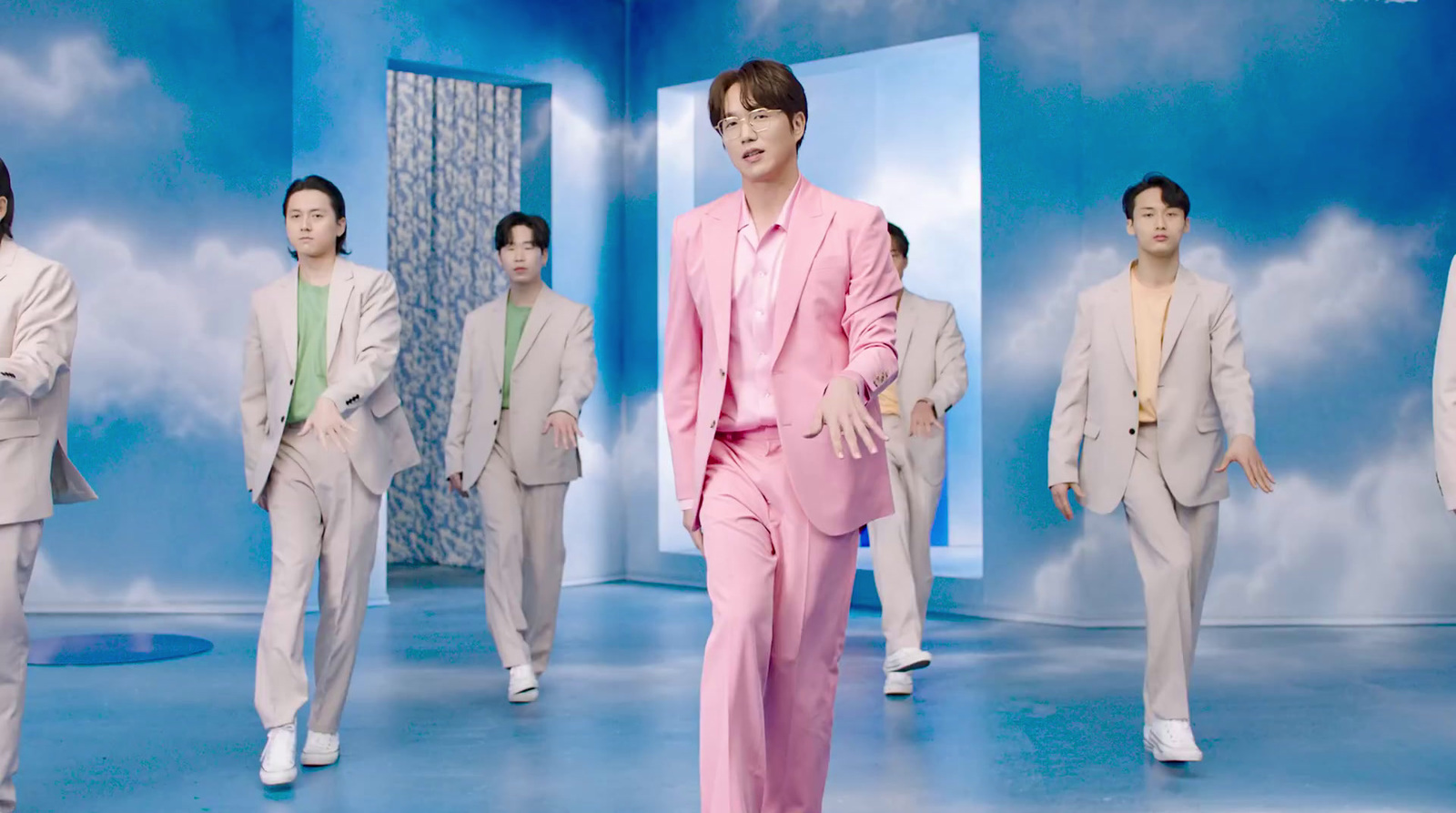 a man in a pink suit is walking in front of a group of other men