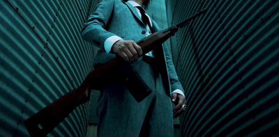 a man in a suit and tie holding a gun