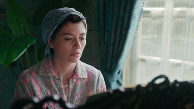 a woman with a turban sitting in front of a window