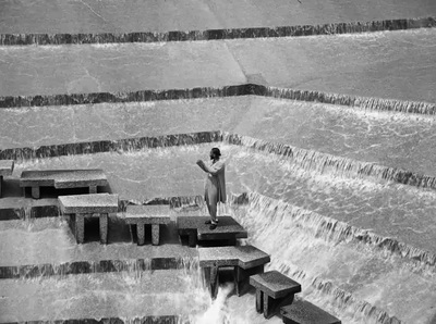 a person standing on a bench in front of a waterfall