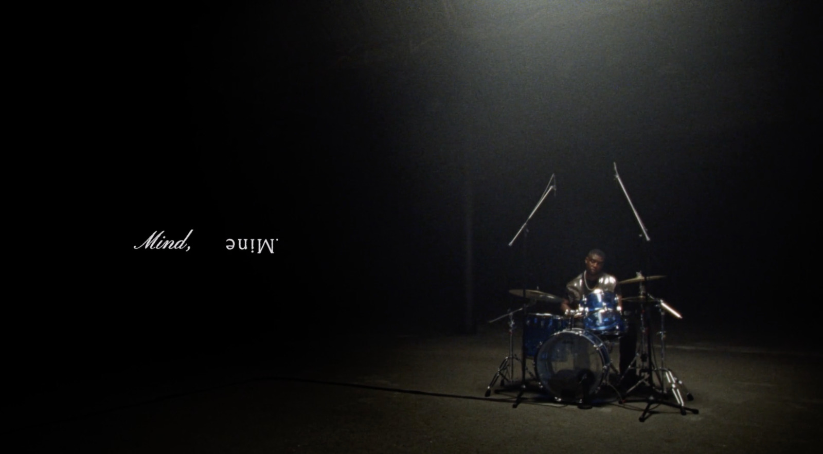 a drummer playing drums in a dark room