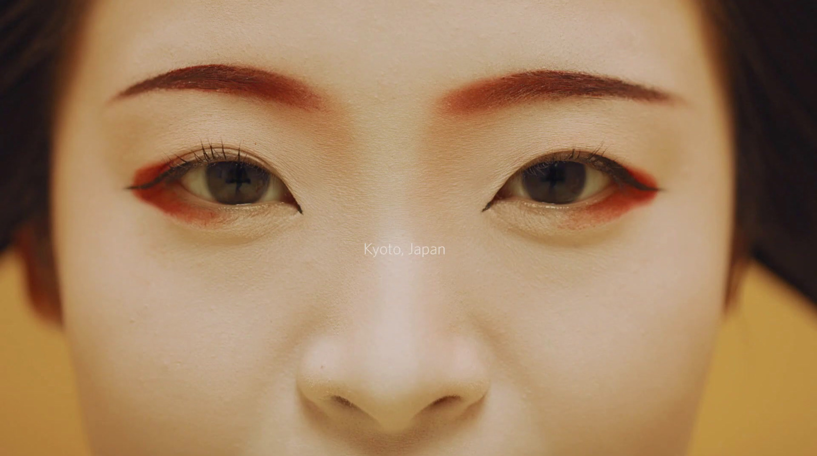 a close up of a woman's face with red eyeliners