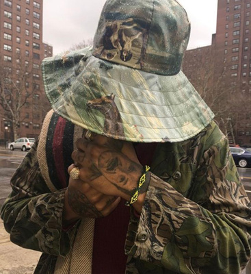a man wearing a camouflage hat on a city street
