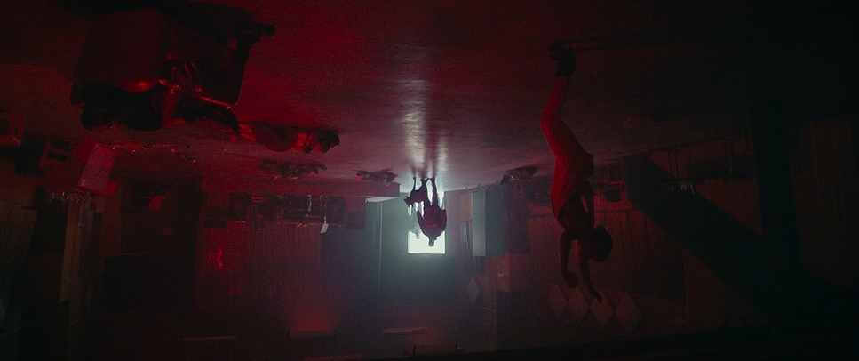 a dark room with a person hanging upside down