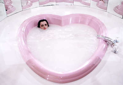 a heart shaped bathtub with a woman in it