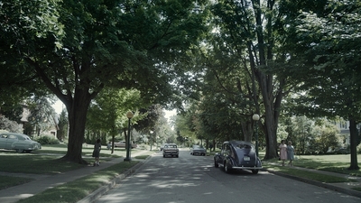 a car parked on the side of a road next to trees