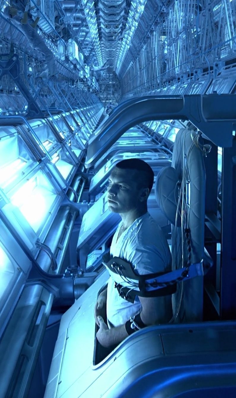 a man in a white shirt is sitting in a space station