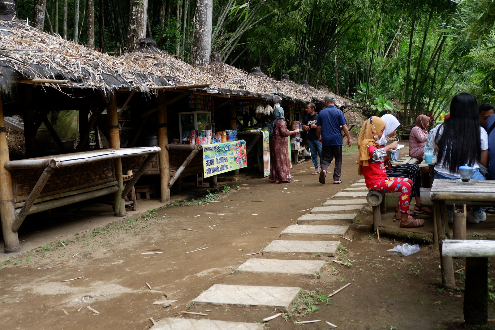 a group of people standing outside of a hut