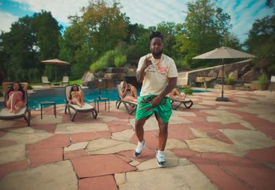 a man in a white shirt and green shorts playing a game of frisbee