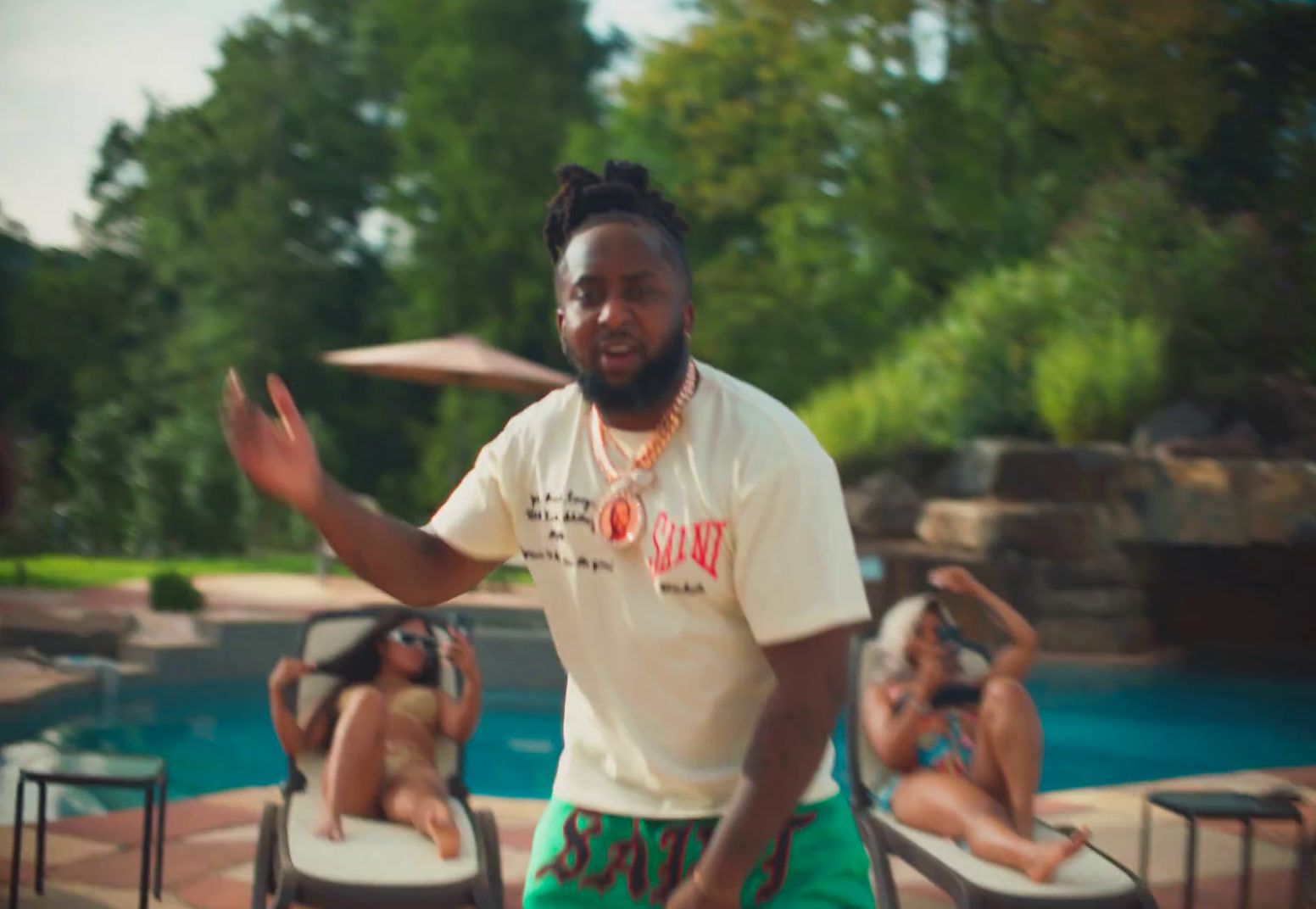 a man standing in front of a pool throwing a frisbee