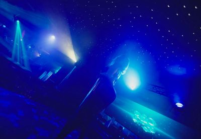 a person standing in front of a stage with blue lights