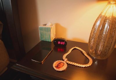 a table with a clock and a necklace on it