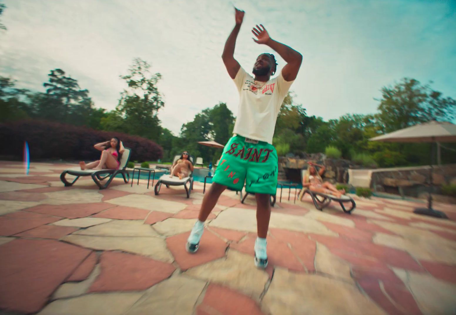 a man in a white shirt and green shorts is playing frisbee