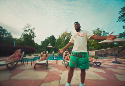 a man standing in front of a pool throwing a frisbee