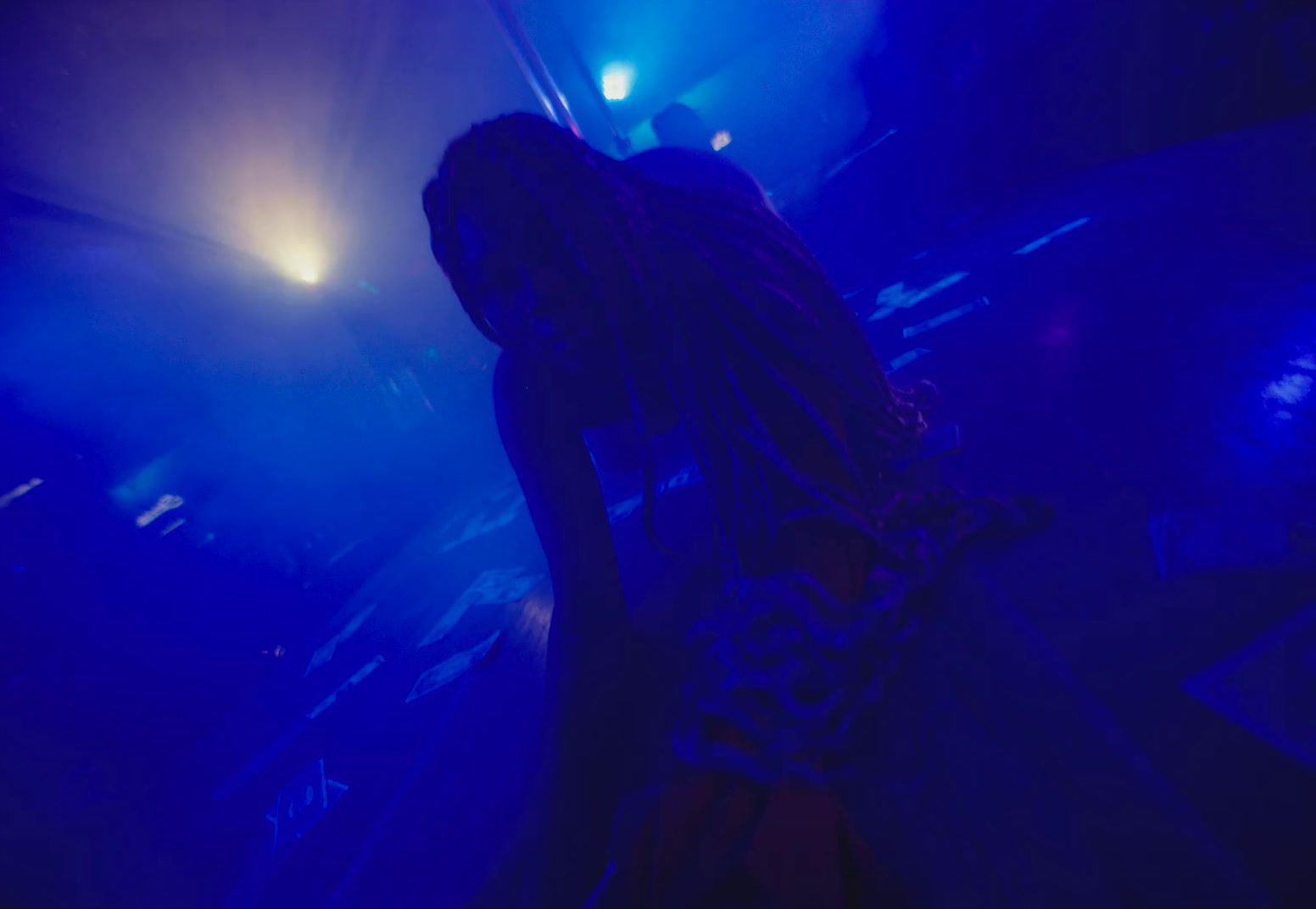 a woman standing in front of a blue light