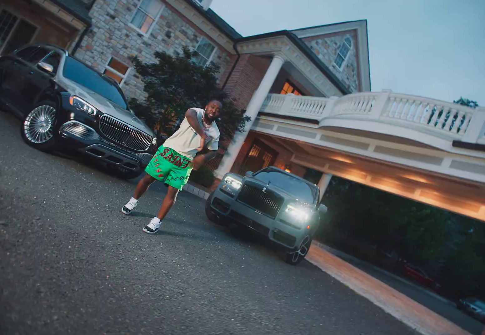 a man standing in front of a car in front of a house