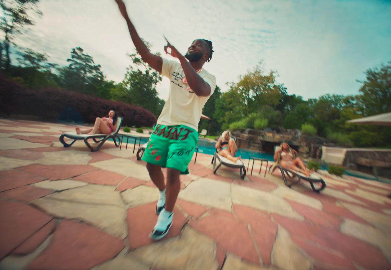 a man in green shorts playing a game of tennis