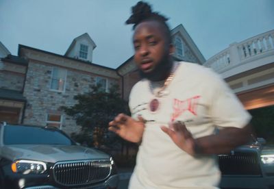 a man standing in front of a car in front of a house